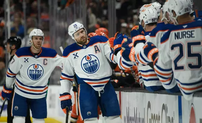 Edmonton Oilers center Leon Draisaitl celebrates a goal by center Ryan Nugent-Hopkins with the bench during the first period of Game 4 in the first round of an NHL hockey Stanley Cup playoff series against the Anaheim Ducks, Sunday, April 26, 2026, in Anaheim, Calif. (AP Photo/Kyusung Gong)