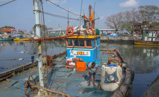 A fisherman washes his face on the deck of a boat anchored at Sassoon Dock in Mumbai, India, Tuesday, April 7, 2026. (AP Photo/Rafiq Maqbool)