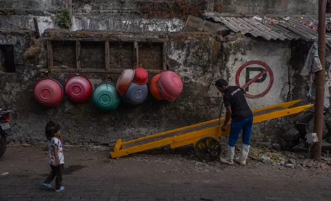 Empty fishing baskets are seen hanging on the wall outside a fish market at Sassoon Dock In Mumbai, India, Wednesday, April 8, 2026. (AP Photo/Rafiq Maqbool)