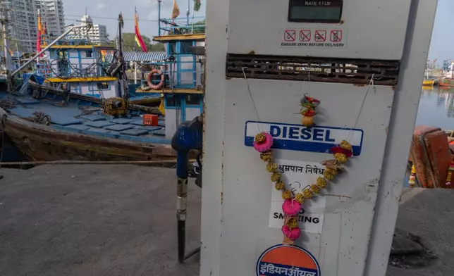 A dry marigold garland hangs at a cooperative diesel pump that is shut due to rising bulk fuel prices at Sassoon Dock in Mumbai, India, Tuesday, April 7, 2026. (AP Photo/Rafiq Maqbool)