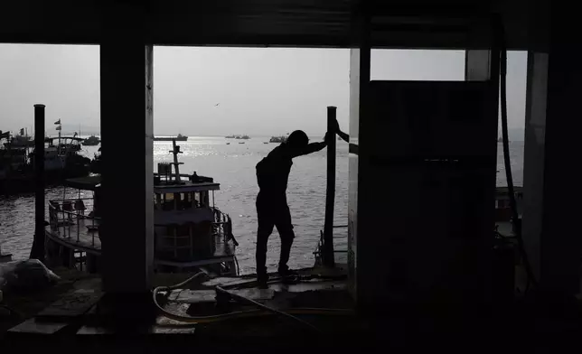 A fisherman stands next to a cooperative diesel pump that is shut due to rising bulk fuel prices at Bhaucha Dhakka in Mumbai, India, Wednesday, April 8, 2026. (AP Photo/Rafiq Maqbool)