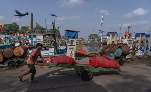 A deckhand pushes a handcart at Sassoon Dock beside a cooperative diesel pump that is shut due to rising bulk fuel prices in Mumbai, India, Tuesday, April 7, 2026. (AP Photo/Rafiq Maqbool)