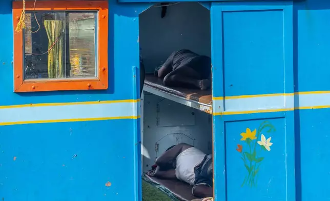 Fishermen nap inside their boat anchored at Sassoon Dock in Mumbai, India, Tuesday, April 7, 2026. (AP Photo/Rafiq Maqbool)