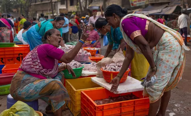 A fisherwoman haggles with a customer over price of fish at a fishmarket at Bhaucha Dhaka in Mumbai, India, Wednesday, April 8, 2026. (AP Photo/Rafiq Maqbool)