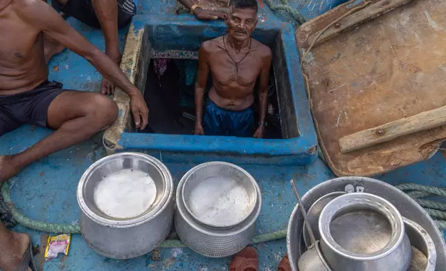 A fisherman stands inside his boat anchored due the price high at Sassoon Dock in Mumbai, India, Tuesday, April 7, 2026. (AP Photo/Rafiq Maqbool)