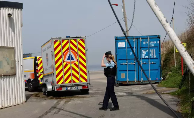 A police officer stands guard after at least four people died while trying to board an inflatable boat for a dangerous sea crossing from northern France to the U.K. in Equihen-Plage, northern France. Thursday, April 9, 2026. (AP Photo/Jean-Francois Badias)