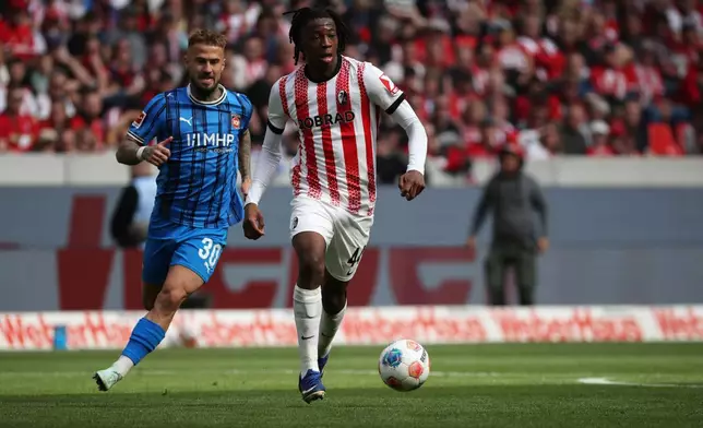 Heidenheim's Niklas Dorsch, left, and Freiburg's Johan Manzambi in a duel during the German Bundesliga soccer match between SC Freiburg and 1. FC Heidenheim in Freiburg, Germany, Sunday April 19, 2026. (Philipp von Ditfurth/dpa via AP)
