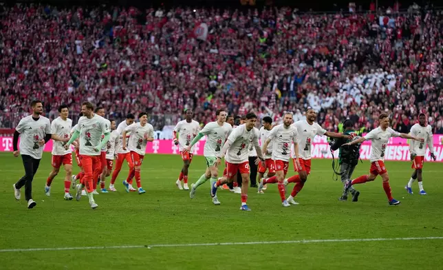 Bayern players celebrate after their team clinched the German league title after a Bundesliga soccer match between Bayern and Stuttgart in Munich, Germany, Sunday, April 19, 2026. (AP Photo/Matthias Schrader)