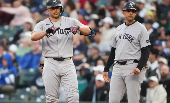 New York Yankees designated hitter Giancarlo Stanton reacts after hitting an RBI single against the Seattle Mariners during the first inning of a baseball game, Tuesday, March 31, 2026, in Seattle. (AP Photo/Lindsey Wasson)