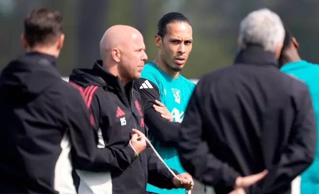 Liverpool's Virgil van Dijk, center, and manager Arne Slot, second left, attend a training session in Liverpool, England, Tuesday April 7, 2026. (Peter Byrne/PA via AP)