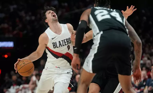 Portland Trail Blazers forward Deni Avdija (8) is fouled as he drives against the San Antonio Spurs during the second half in Game 3 of a first-round NBA playoffs basketball series in Portland, Ore, Friday, April 24, 2026. (AP Photo/Jenny Kane)