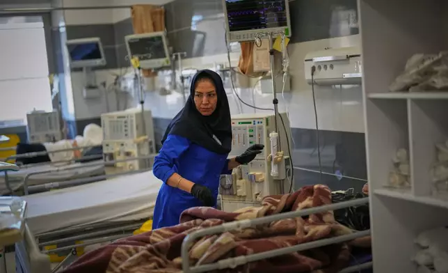 A nurse attends to a patient at Shohadaye Tajrish Hospital in Tehran, Iran, Tuesday, April 7, 2026. (AP Photo/Francisco Seco)