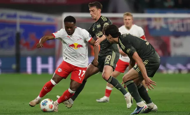 Leipzig's Ridle Baku, left, dribbles as Union Berlin's Janik Haberer, center, and Diogo Leite defend during a Bundesliga soccer match between RB Leipzig and 1. FC Union Berlin, Friday, April 24, 2026, in Leipzig, Germany. (Jan Woitas/dpa via AP)