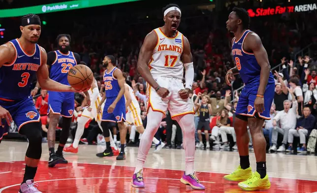 Atlanta Hawks forward Onyeka Okongwu (17) reacts after a dunk against New York Knicks guard Josh Hart (3) and forward Og Anunoby (8) during the first half in Game 3 of a first-round NBA playoffs basketball series, Thursday, April 23, 2026, in Atlanta. (AP Photo/Colin Hubbard)