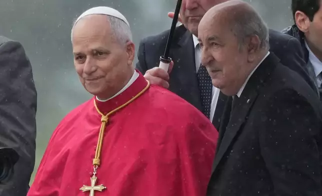 Pope Leo XIV is welcomed by Algerian President Abdelmadjid Tebboune, right, upon his arrival at Algiers' Houari Boumédiène International Airport on Monday, April 13, 2026, at the start of an 11-day apostolic journey to Africa. (AP Photo/Andrew Medichini)