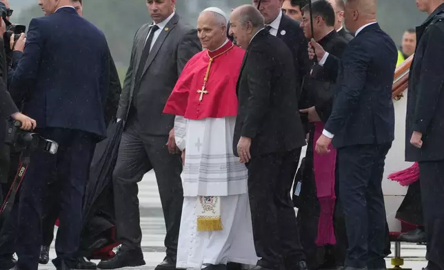 Pope Leo XIV is welcomed by Algerian President Abdelmadjid Tebboune, center right, upon his arrival at Algiers' Houari Boumédiène International Airport on Monday, April 13, 2026, at the start of an 11-day apostolic journey to Africa. (AP Photo/Andrew Medichini)