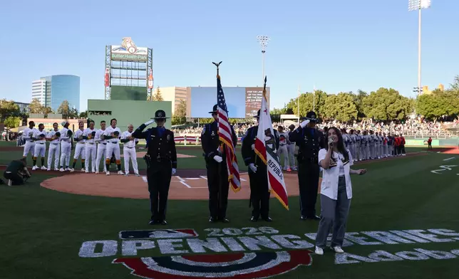 The national anthem is sung before a home-opener baseball game between the Athletics and the Houston Astros, Friday, April 3, 2026, in West Sacramento, Calif. (AP Photo/Sara Nevis)
