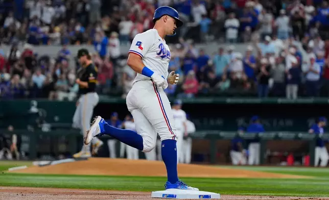 Texas Rangers' Josh Jung rounds third after hitting a two-run home run off a pitch from Pittsburgh Pirates pitcher Braxton Ashcraft, left rear, in the second inning of a baseball game Wednesday, April 22, 2026, in Arlington, Texas. (AP Photo/Tony Gutierrez)