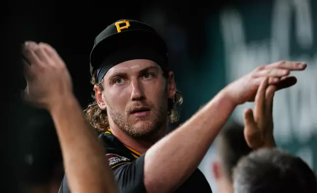 Pittsburgh Pirates pitcher Braxton Ashcraft hi-fives with teammates in the dugout after working against the Texas Rangers in the seventh inning of a baseball game Wednesday, April 22, 2026, in Arlington, Texas. (AP Photo/Tony Gutierrez)