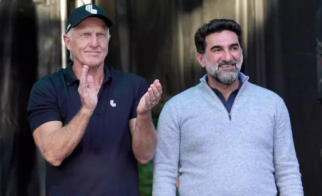 FILE - LIV Golf CEO Greg Norman, left, applauds Yasir Al-Rumayyan, Governor of Public Investment Fund of Saudi Arabia, at the LIV Golf Invitational-Chicago tournament Sept. 18, 2022, in Sugar Hill, Ill. (AP Photo/Charles Rex Arbogast, File)