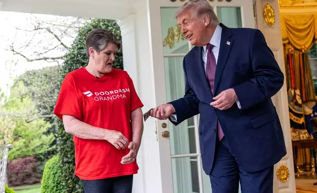 Sharon Simmons with DoorDash, gets a $100 tip after delivering McDonald's to President Donald Trump in the Oval Office of the White House, Monday, April 13, 2026, in Washington. (AP Photo/Alex Brandon)