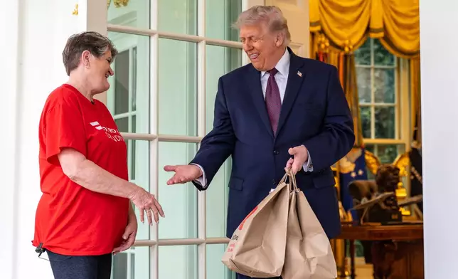 Sharon Simmons, with DoorDash, delivers McDonald's to President Donald Trump outside the Oval Office of the White House, Monday, April 13, 2026, in Washington. (AP Photo/Alex Brandon)