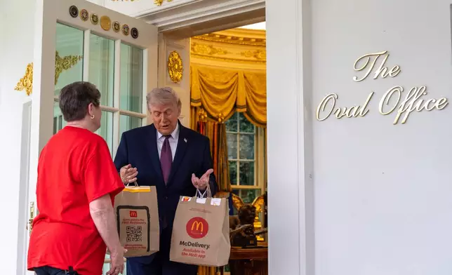 Sharon Simmons with DoorDash, delivers McDonald's to President Donald Trump in the Oval Office of the White House, Monday, April 13, 2026, in Washington. (AP Photo/Alex Brandon)
