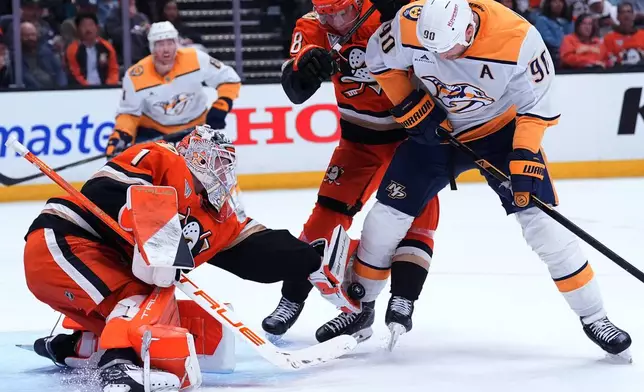 Anaheim Ducks' goaltender Lukas Dostal reaches of the puck against Nashville Predators' center Ryan O'Reilly (90) during the second period of an NHL hockey game Tuesday, April 7, 2026, in Anaheim, Calif.. (AP Photo/Scott Strazzante)