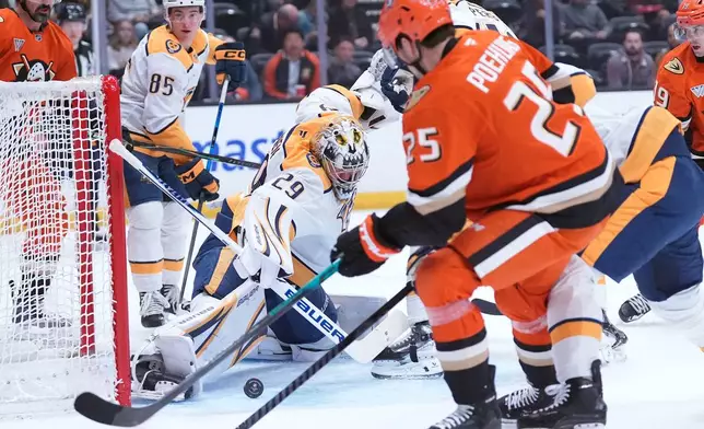 Nashville Predators' goaltender Justus Annunen (29) saves a shot by Anaheim Ducks' center Ryan Poehling (25) during the first period of an NHL hockey game Tuesday, April 7, 2026, in Anaheim, Calif.. (AP Photo/Scott Strazzante)