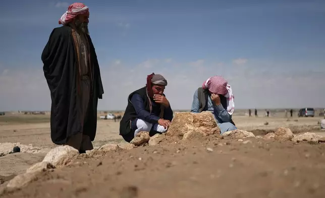 Mourners kneel by the graves of six people from the Al-Jalib family, who were killed Wednesday in Israeli strikes in Beirut, after their burial in the village of al-Sour, Deir al-Zour province, northeastern Syria, Saturday, April 11, 2026. (AP Photo/Ghaith Alsayed)