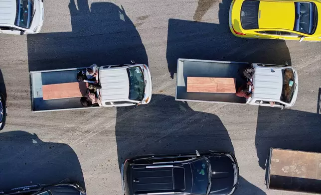 Two of the six coffins of members of the Al-Jalib family, who were killed Wednesday in Israeli strikes in Beirut, are carried for burial during their funeral in the village of al-Sour, Deir al-Zour province, northeastern Syria, Saturday, April 11, 2026. (AP Photo/Ghaith Alsayed)