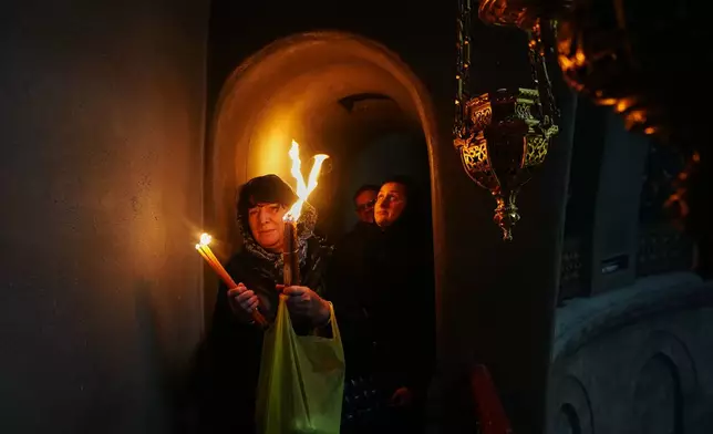 Christian Orthodox pilgrims hold up candles during the Holy Fire ceremony, at the Church of the Holy Sepulcher, the site where, according to tradition, Jesus was crucified and buried, in the Old City of Jerusalem, Saturday, April 11, 2026. (AP Photo/Mahmoud Illean)