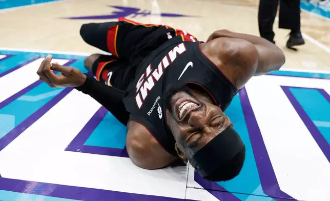 Miami Heat center Bam Adebayo (13) lies on the court during the first half of an NBA play-in tournament basketball game against the Charlotte Hornets in Charlotte, N.C., Tuesday, April 14, 2026. (AP Photo/Nell Redmond)