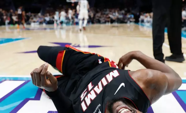 Miami Heat center Bam Adebayo (13) lies on the court during the first half of an NBA play-in tournament basketball game against the Charlotte Hornets in Charlotte, N.C., Tuesday, April 14, 2026. (AP Photo/Nell Redmond)