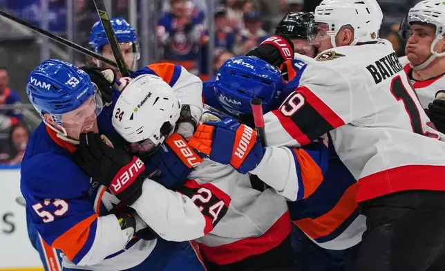 New York Islanders' Casey Cizikas (53) fihts with Ottawa Senators' Dylan Cozens (24) during the third period of an NHL hockey game Saturday, April 11, 2026, in Elmont, N.Y. (AP Photo/Frank Franklin II)