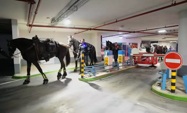 Police officers and their horses take cover in an underground parking garage as sirens warn of an incoming missile fired from Yemen in Tel Aviv, Israel, Saturday, April 4, 2026. (AP Photo/Maya Levin)