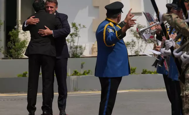 Cypriot President Nikos Christodoulides, foreground, welcomes his French counterpart Emmanuel Macron at the presidential palace in Nicosia, Cyprus, Thursday, April 23, 2026. (AP Photo/Petros Karadjias)