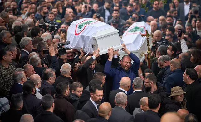 Men carry the coffins with the bodies of Pierre Mouawad, an official with the anti-Hezbollah Lebanese Forces party, and his wife during their funeral in Yahshush, Lebanon, Tuesday, April 7, 2026. (AP Photo/Emilio Morenatti)