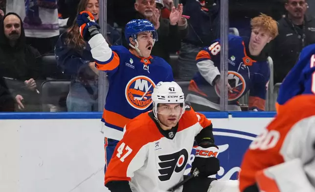 New York Islanders' Jean-Gabriel Pageau, left, celebrates after scoring a goal as Philadelphia Flyers' Noah Juulsen (47) reacts during the second period of an NHL hockey game Friday, April 3, 2026, in Elmont, N.Y. (AP Photo/Frank Franklin II)