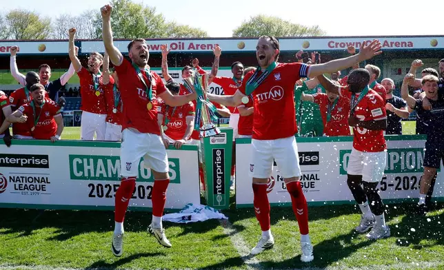 York City players and staff celebrate with the trophy after defeating Rochdale in the National League match in Rochdale, England, Saturday April 25, 2026. (Cody Froggatt/PA via AP)