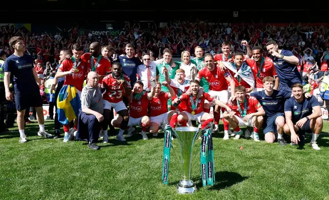 York City players and staff celebrate with the trophy after defeating Rochdale in the National League match in Rochdale, England, Saturday April 25, 2026. (Cody Froggatt/PA via AP)