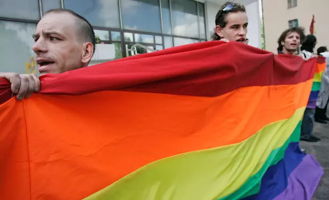 FILE - Activists hold a rainbow flag as they march during a pride parade in Minsk, Belarus, Saturday, May 15, 2010. (AP Photo, File)