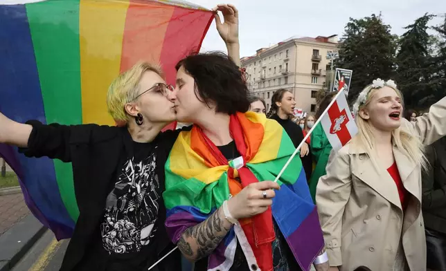 FILE - Two LGBT activists kiss while holding rainbow's flags during an opposition rally to protest the official presidential election results in Minsk, Belarus, Saturday, Sept. 5, 2020.(AP Photo, File)