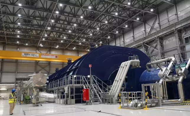 A member of the media stands in the turbine hall of Olkiluoto 3 (OL3), Europe's largest nuclear reactor, during a press tour on the island of Olkiluoto, Finland, Tuesday, Feb. 24, 2026. (AP Photo/James Brooks)