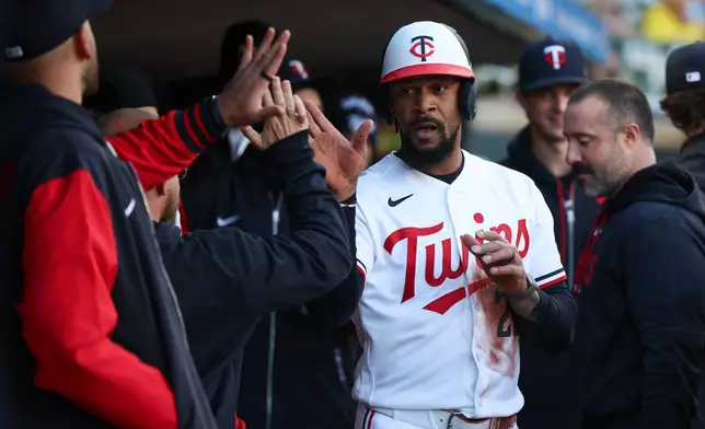 Minnesota Twins' Byron Buxton (25) celebrates in the dugout after scoring during the first inning of a baseball game against the Detroit Tigers Wednesday, April 8, 2026, in Minneapolis. (AP Photo/Ellen Schmidt)