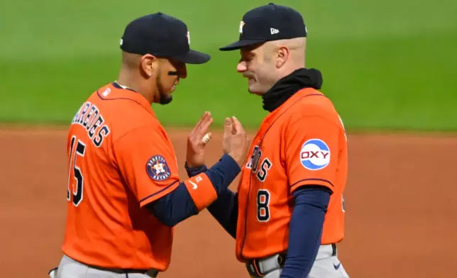 Houston Astros' Isaac Paredes, left, and Christian Walker, right, celebrate a win over the Cleveland Guardians in a baseball game in Cleveland, Monday, April 20, 2026. (AP Photo/David Richard)