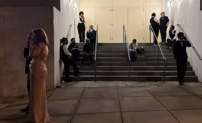 Attendees and hotel workers evacuate after an incident at the Washington Hilton during the White House Correspondents Dinner, Saturday, April 25, 2026, in Washington. (AP Photo/Mark Schiefelbein)