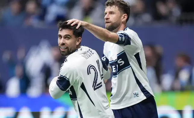 Vancouver Whitecaps' Brian White, front left, and Thomas Muller celebrate White's goal during the second half of an MLS soccer match against New York City FC, in Vancouver, on Saturday, April 11, 2026. (Darryl Dyck/The Canadian Press via AP)