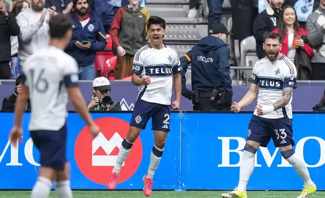 Vancouver Whitecaps' Mathias Laborda (2) and Tristan Blackmon (33) celebrate after Laborda's goal during the first half of an MLS soccer match against New York City FC in Vancouver, British Columbia, Saturday, April 11, 2026. (Darryl Dyck/The Canadian Press via AP)