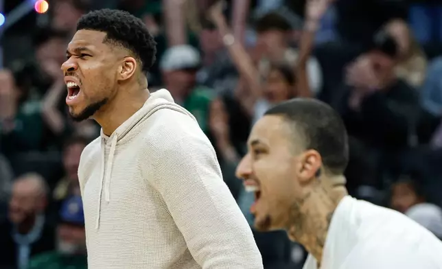 Milwaukee Bucks forward Giannis Antetokounmpo, left and Kyle Kuzma react after teammate AJ Green made a three-pointer against the Brooklyn Nets during an NBA basketball game, Friday, April 10, 2026, in Milwaukee. (AP Photo/Jeffrey Phelps)